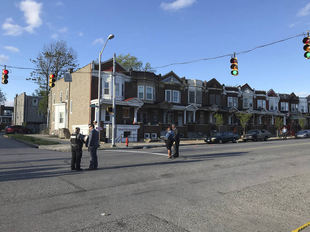 Authorities stand at Edmondson and Whitmore after multiple people were shot, Sunday, April 28, ...