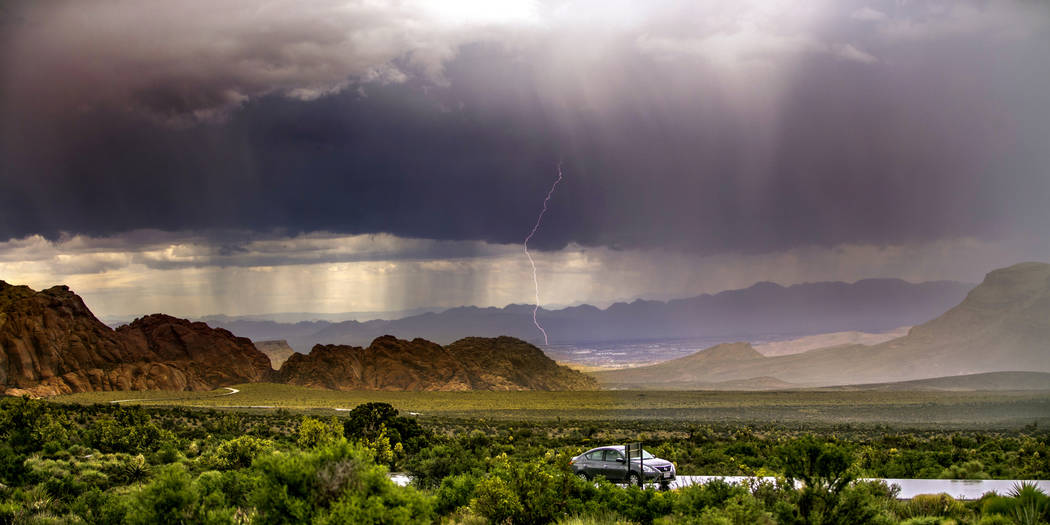 A lightning bolt streaks down as a fast-moving storm makes its way through the Red Rock Canyon ...