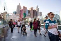 People walk over a pedestrian bridge linking New York-New York and MGM Grand near the intersect ...