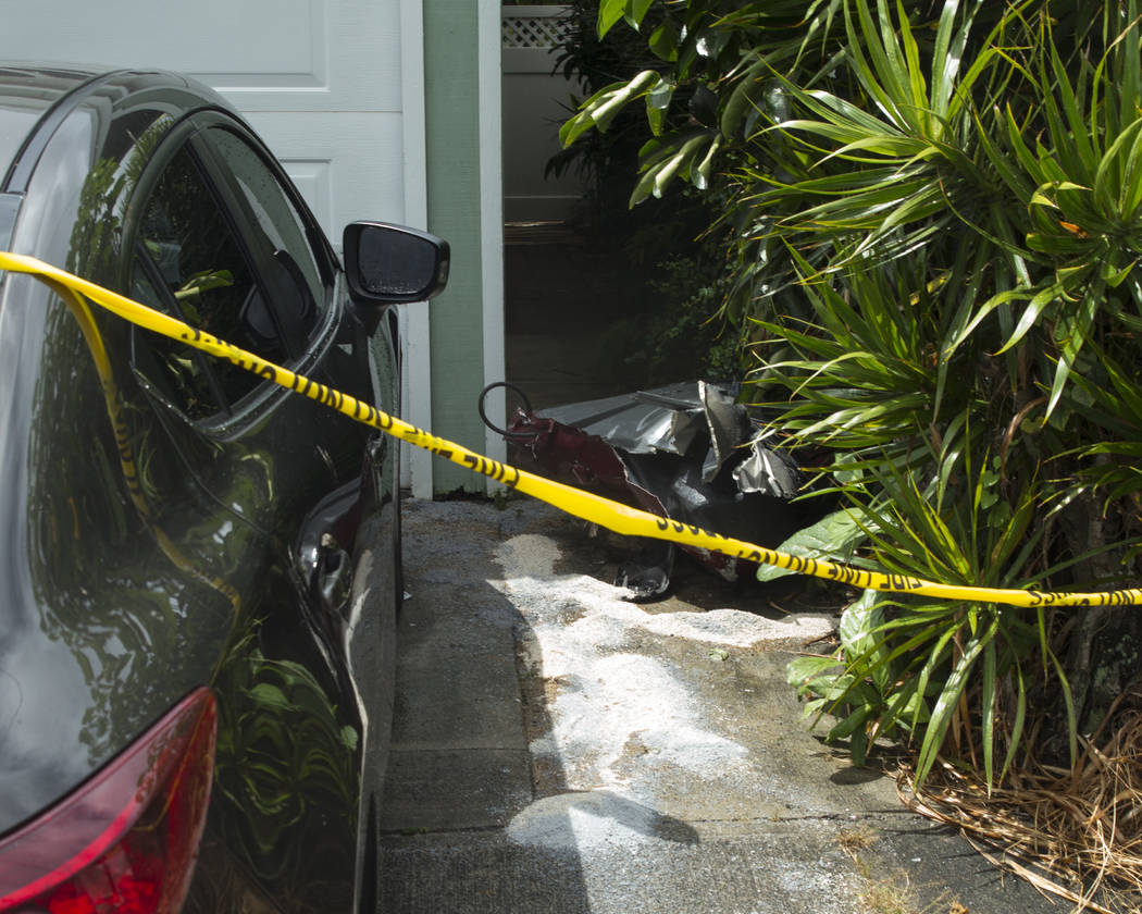 Debris lays on the ground where parts of a helicopter hit a parked car, Monday, April 29, 2019, ...