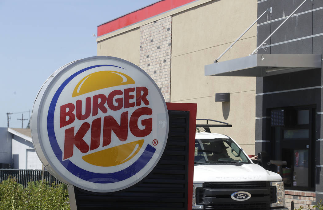 In this Thursday, April 25, 2019, photo a customer takes his order from the drive through windo ...