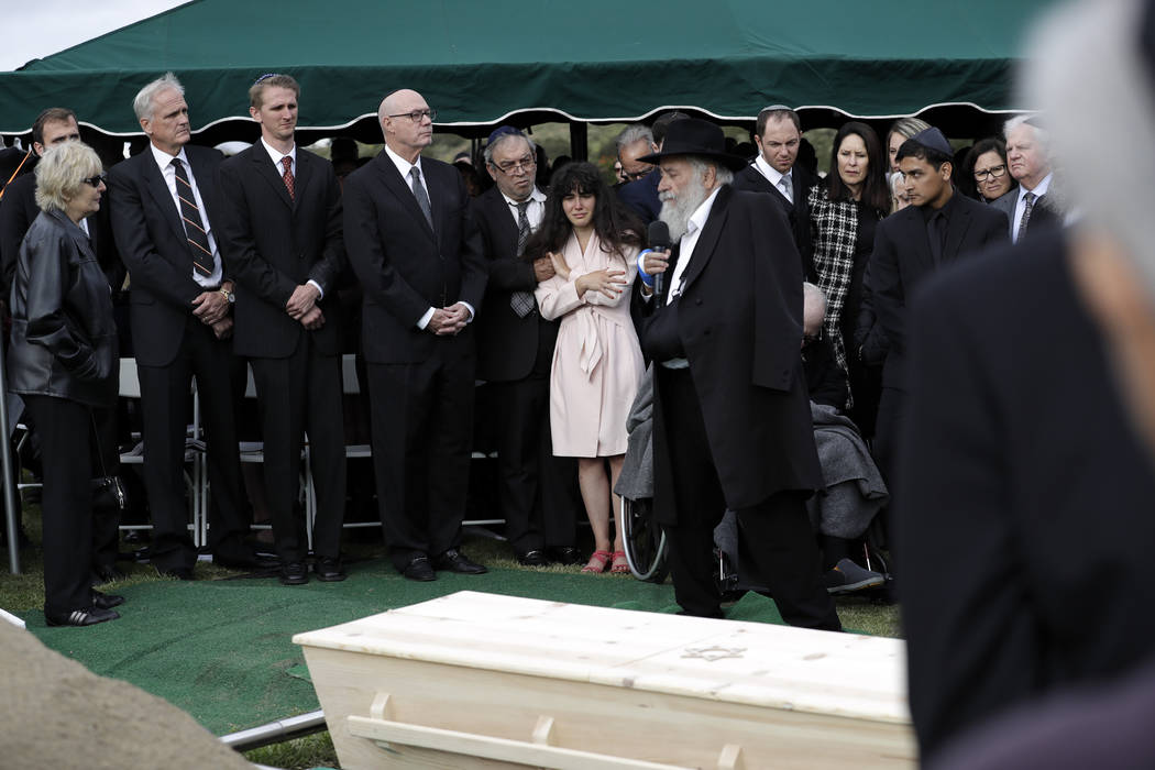 Hannah Kaye, the daughter of shooting victim Lori Kaye, center, holds the hand of her father, H ...