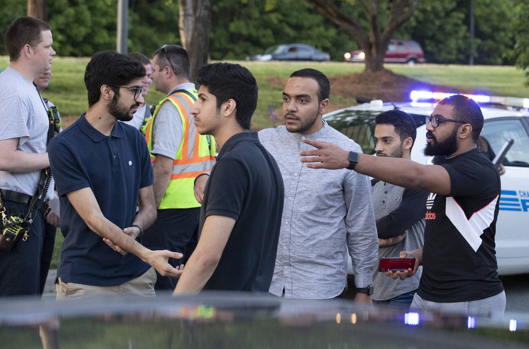 People gather across from the campus of University of North Carolina at Charlotte after a shoot ...