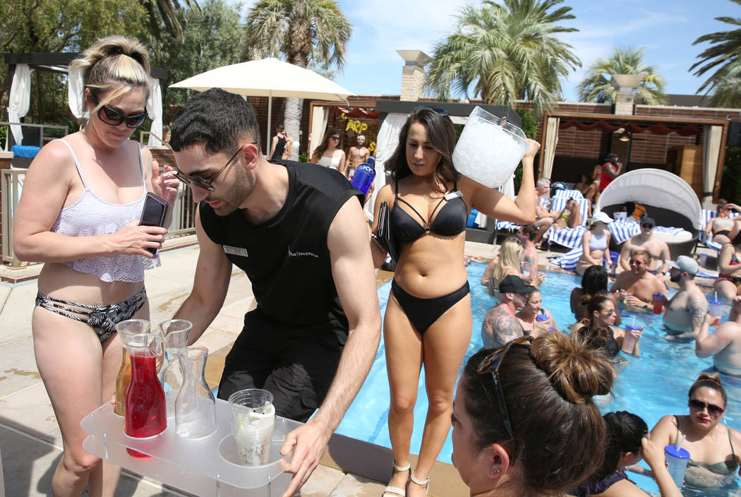 Talih Kadi and Malia Moy, right, both model cocktail servers, serve drinks to hotel guests at M ...