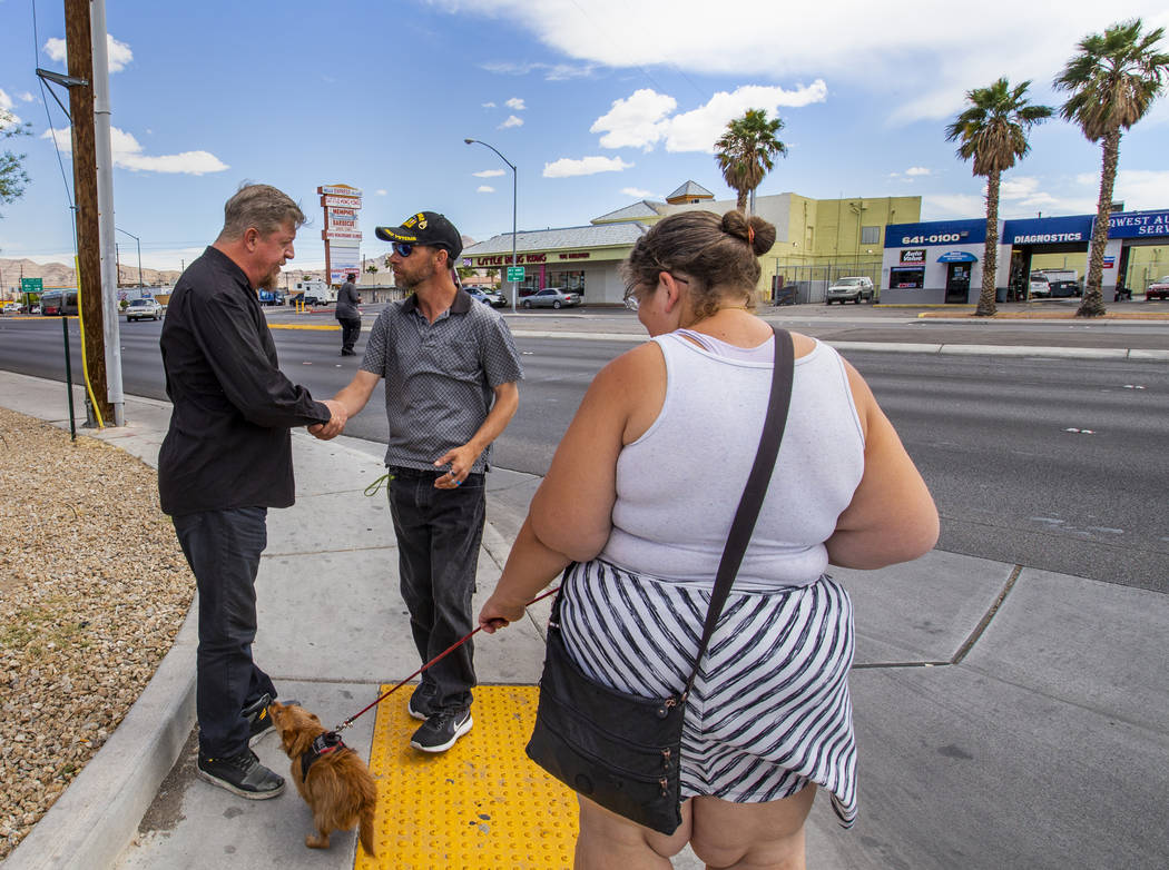 Ron Cochran, with his dog Cookie, says goodbye for the day with friends Christian Bridges and R ...