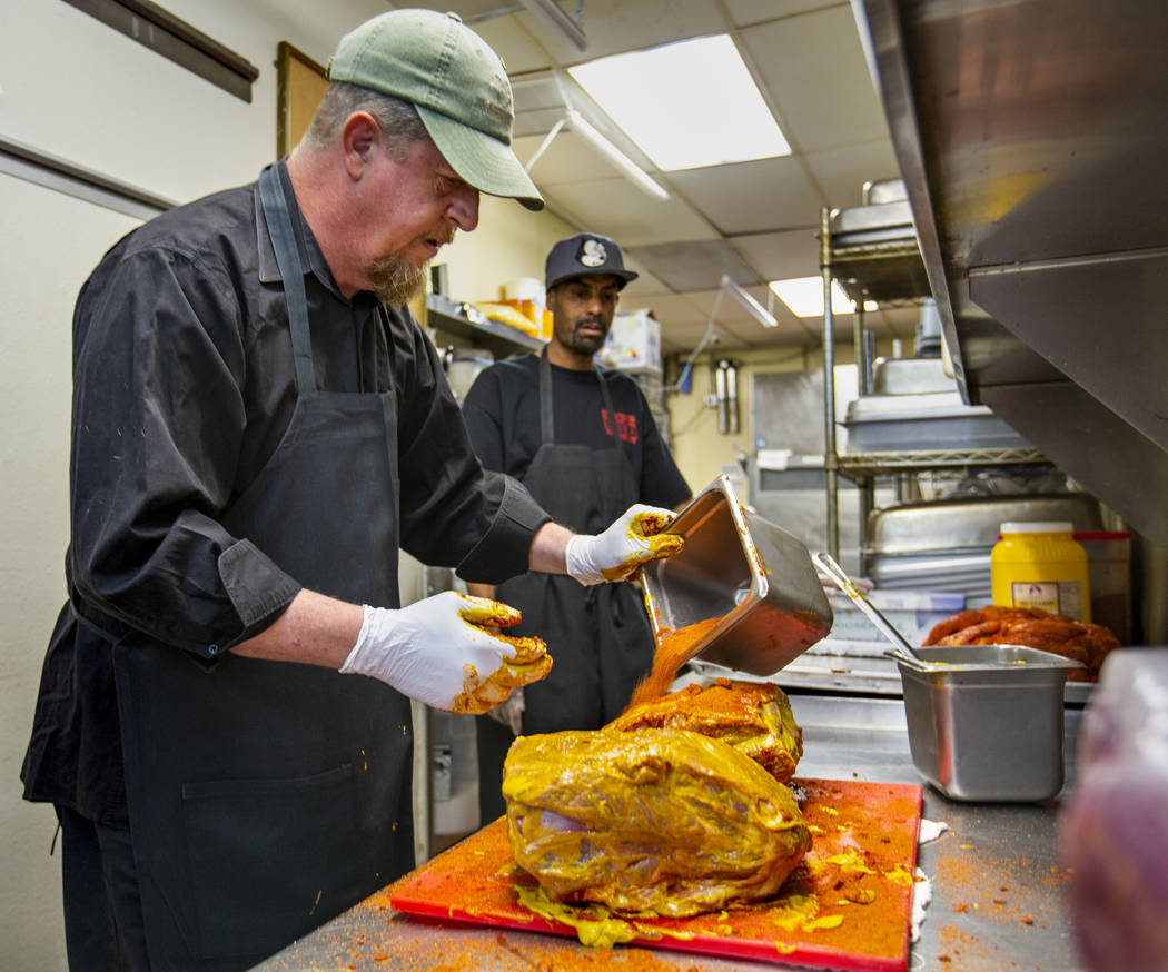 New employee Ron Cochran receives some meat rub training from kitchen prep/smoker Anthony McMah ...