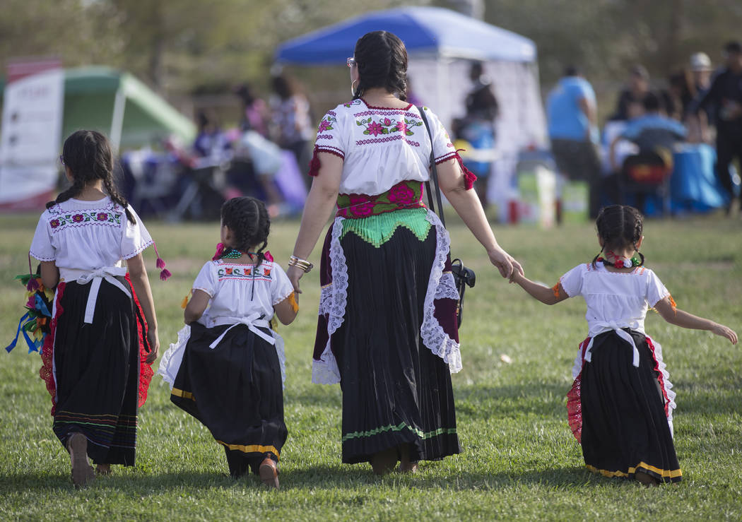 Dancers with Federación de Poblanos en Las Vegas walk on the outfield grass after performing d ...