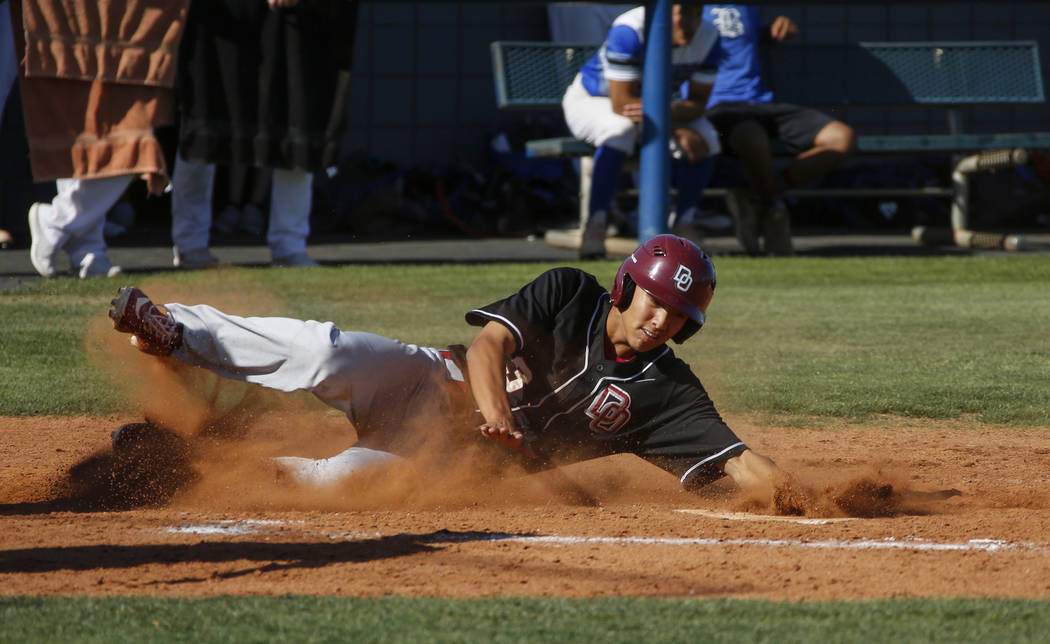 Desert Oasis outfielder Tripp Edens (3) slides into home base in the third inning of a baseball ...