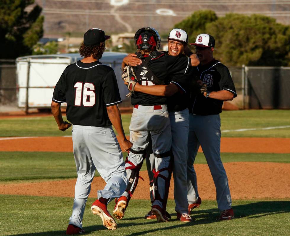 Desert Oasis pitcher Aaron Roberts (25) in congratulated by his teammates after beating Basic H ...