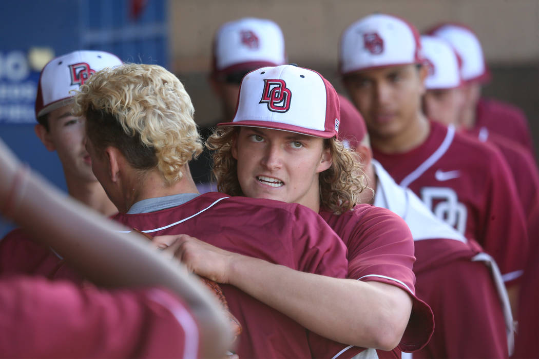 Desert Oasis pitcher Josh Sharman (11), center, hugs a teammate after a scoreless inning agains ...