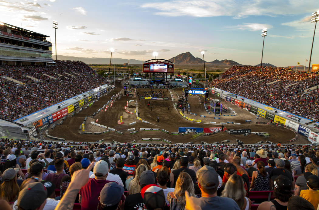 Motorcycles blur by during the featured 450 SX class race at Sam Boyd Stadium on Saturday, May ...