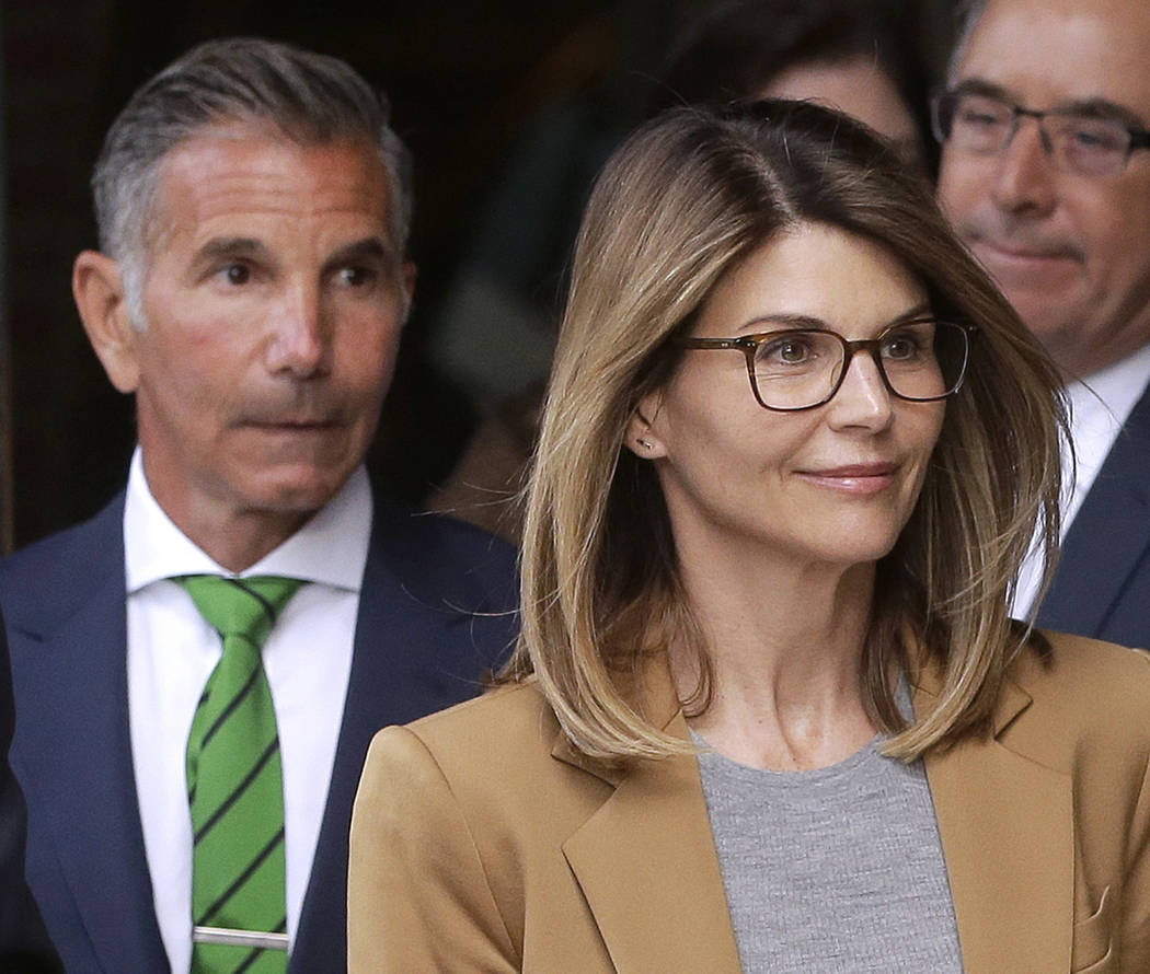 Actress Lori Loughlin, front, and husband, clothing designer Mossimo Giannulli, left, depart fe ...