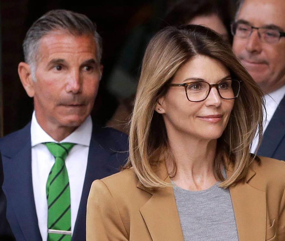 Actress Lori Loughlin, front, and husband, clothing designer Mossimo Giannulli, left, depart fe ...