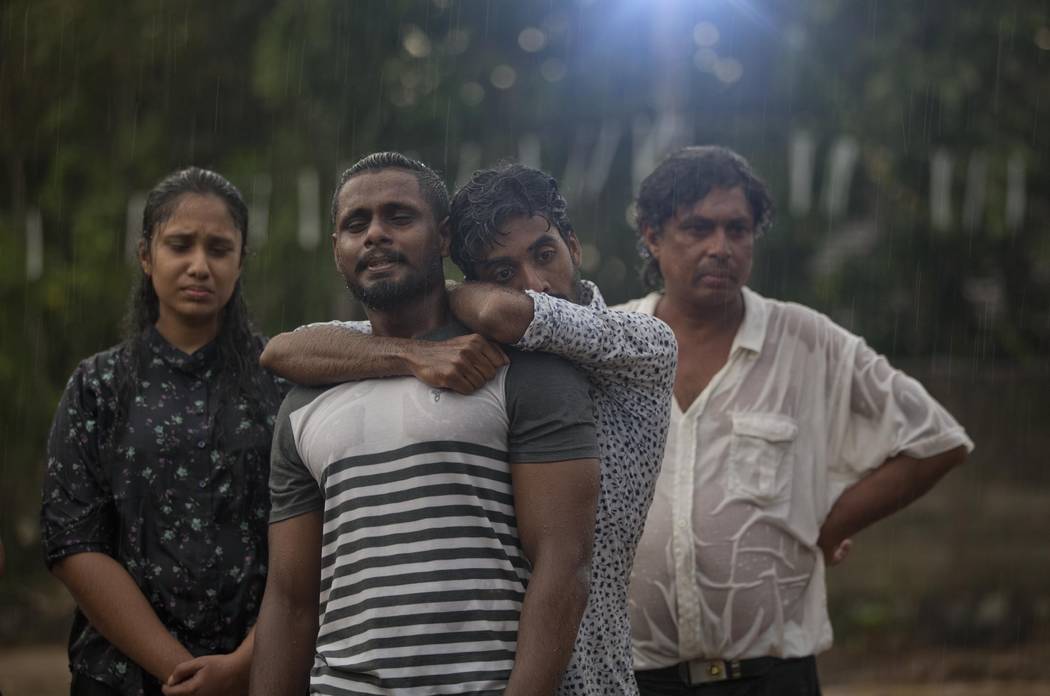 FILE - In this April 22, 2019 file photo, mourners grieve at the burial of three members of th ...