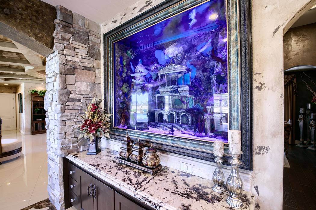 The 700-gallon aquarium in the kitchen has 25 sea creatures, including angelfish, triggers, and ...