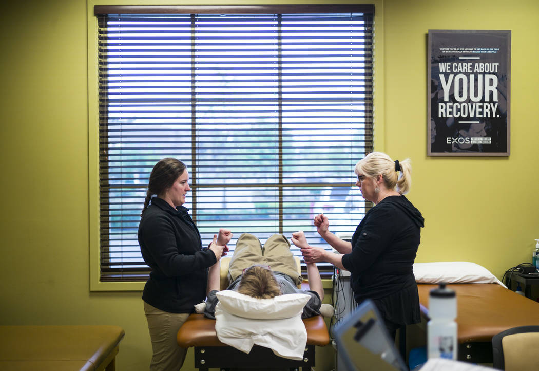 Student physical therapist Meghan Bell, left, demonstrates an excercise on Grayson McClure, cen ...