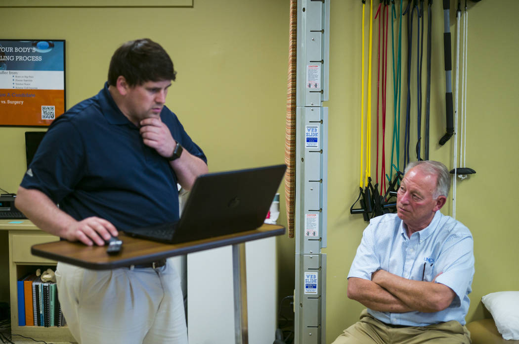 Physical therapist Walker Gardner, left, talks with Terry McClure at EXOS Physical Therapy &amp ...