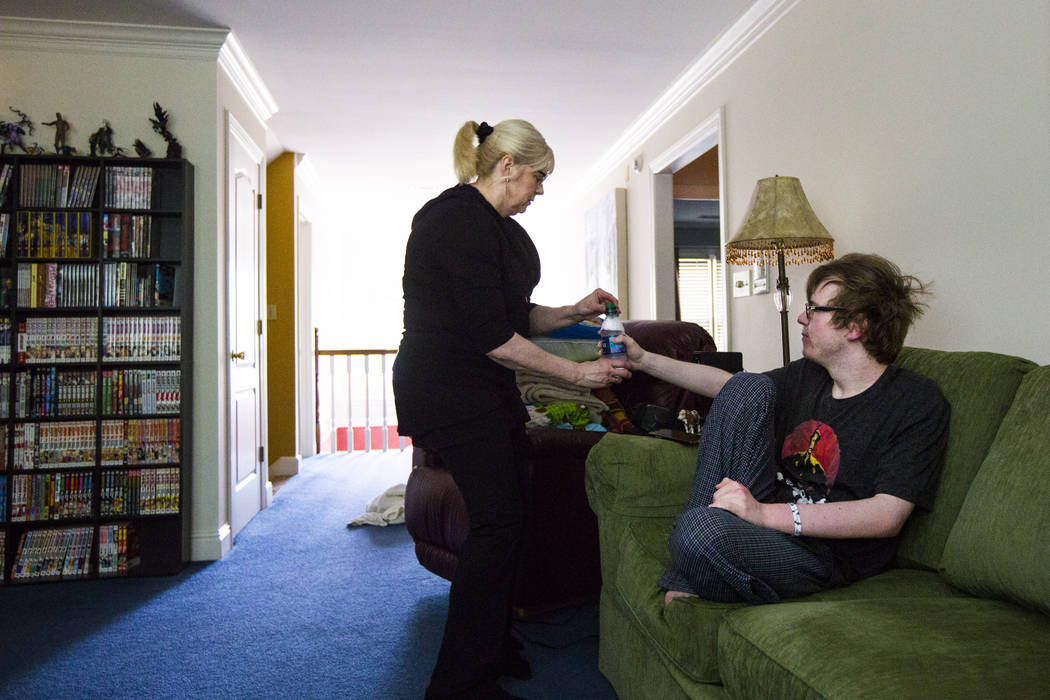 Kay McClure gives her son, Grayson McClure, morning medication at their home in Collierville, T ...