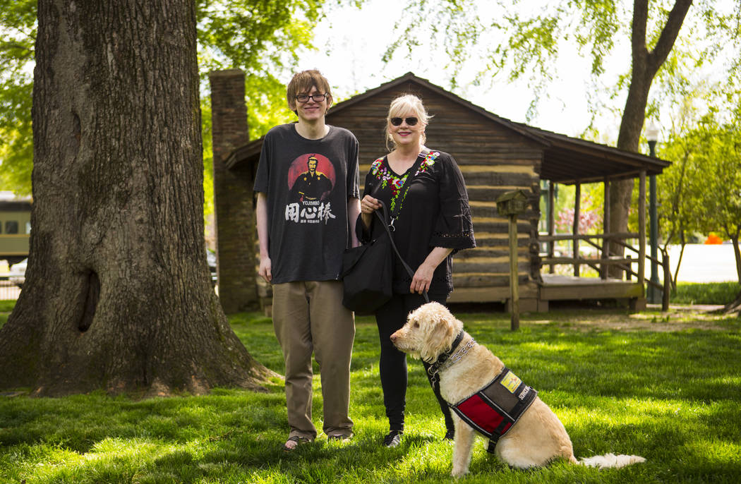 Grayson McClure, left, stands with his mom, Kay McClure, and service dog Yojimbo, at the park a ...