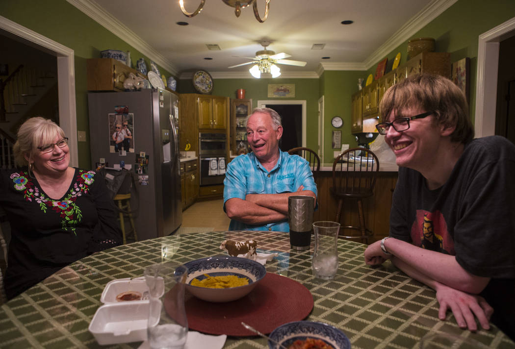 Grayson McClure, right, shares a laugh with his parents, Kay McClure, left, and Terry McClure, ...