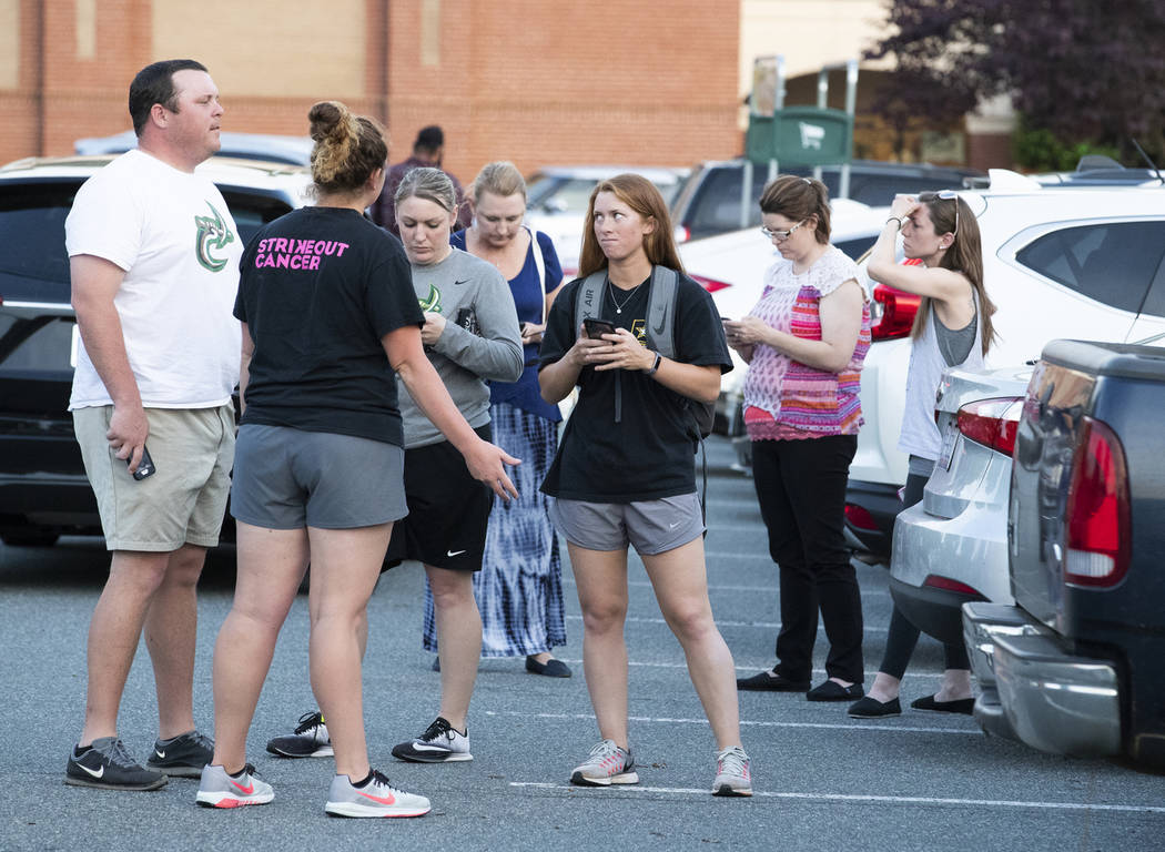 People gather across from the campus of UNC Charlotte after a shooting incident at the school T ...