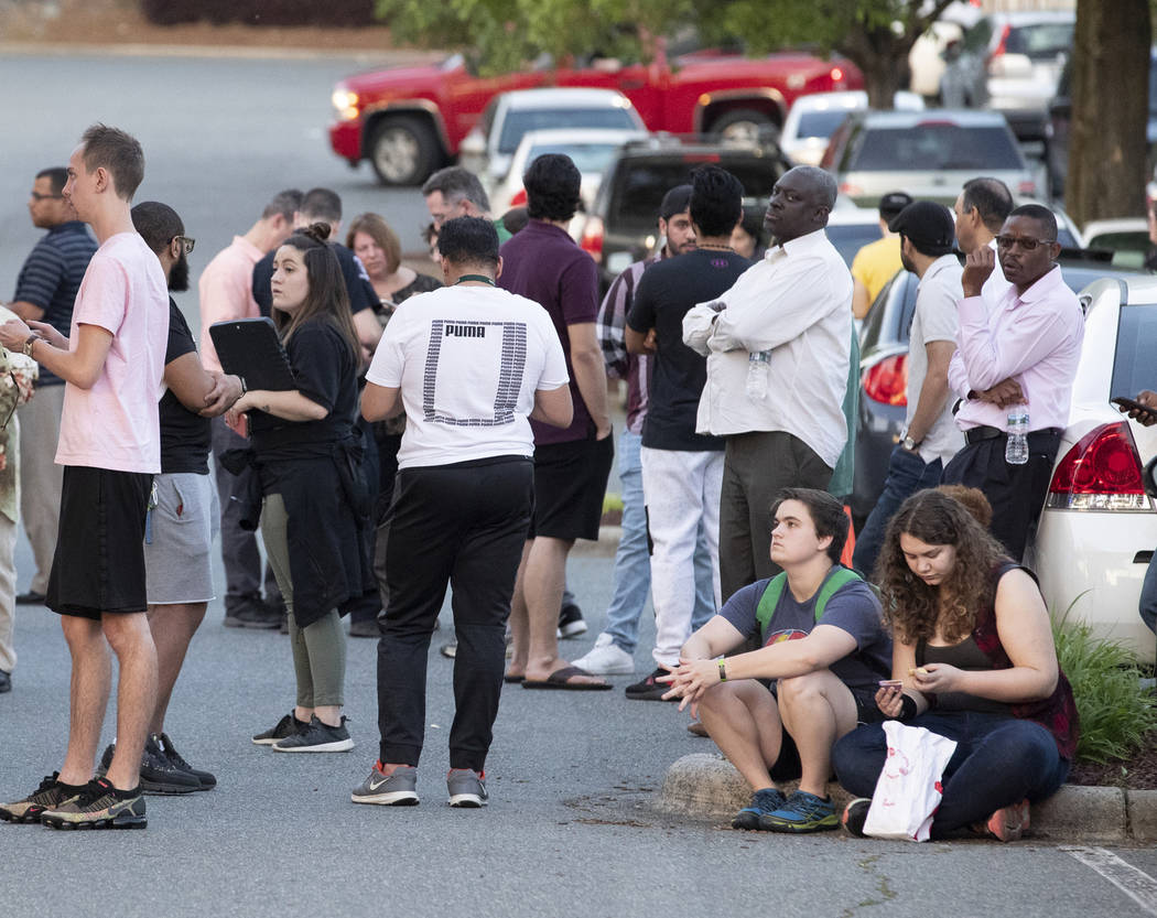 People gather across from the campus of UNC Charlotte after a shooting incident at the school T ...