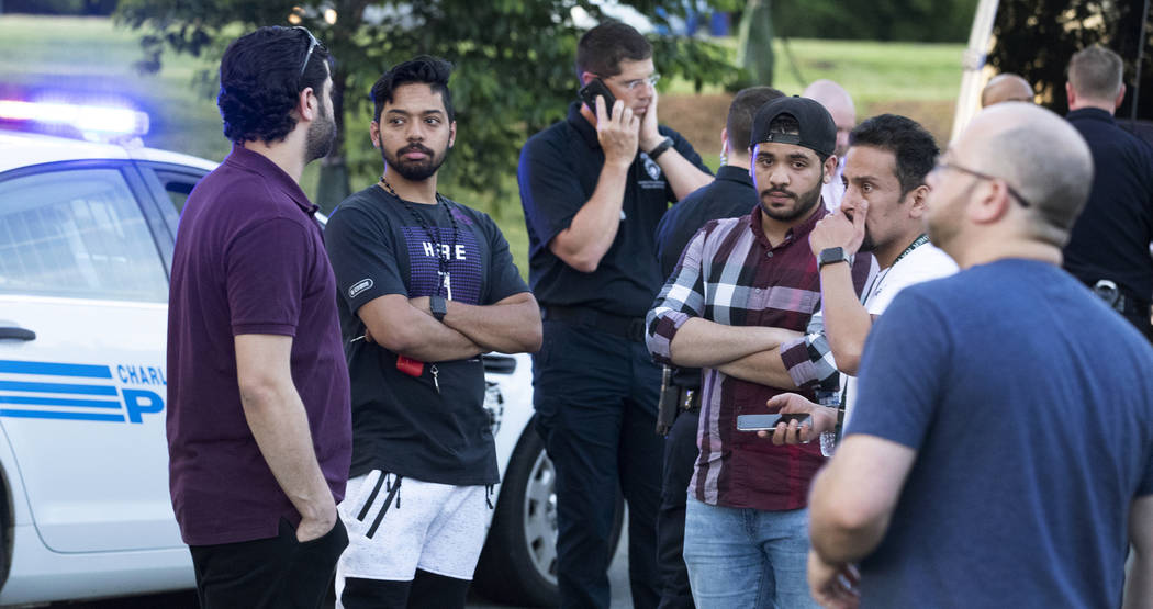 People gather across from the campus of UNC Charlotte after a fatal shooting at the school, Tue ...