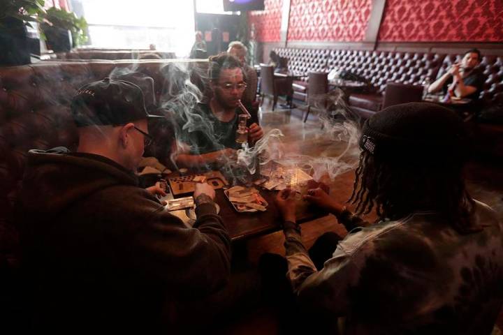 In this March 1, 2018, file photo, patrons at a San Francisco dispensary smoke marijuana. Legal ...