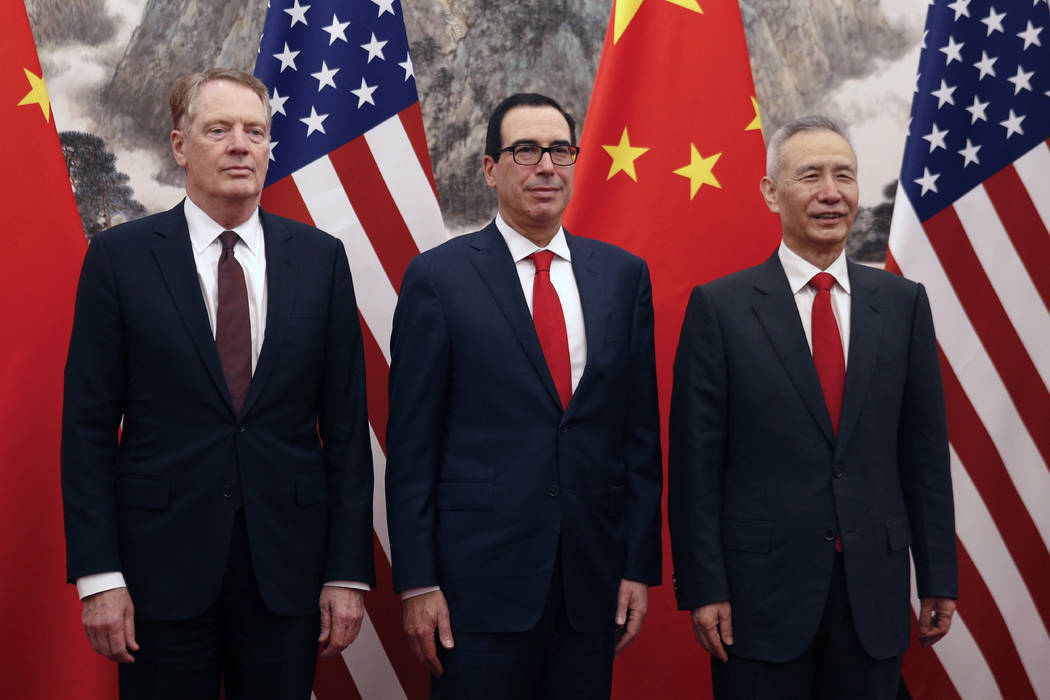 Chinese Vice Premier Liu He, right, poses with U.S. Treasury Secretary Steven Mnuchin, center, ...