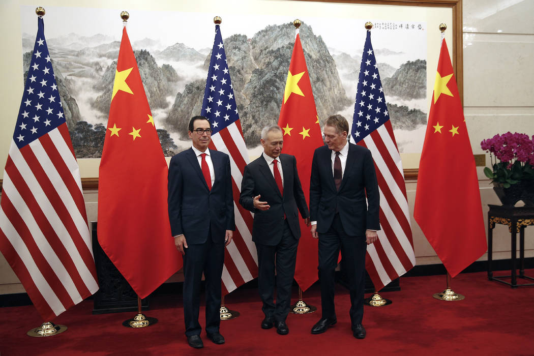 Chinese Vice Premier Liu He, center, chats with U.S. Trade Representative Robert Lighthizer, ri ...