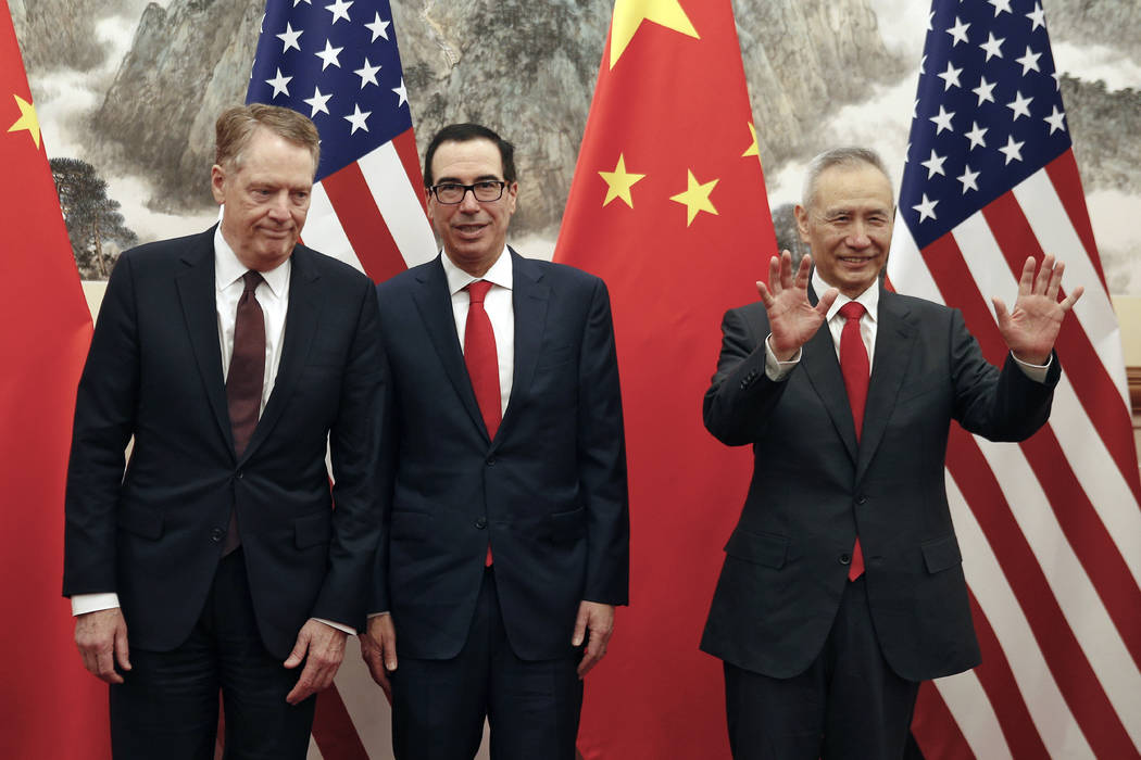 Chinese Vice Premier Liu He, right, gestures as U.S. Treasury Secretary Steven Mnuchin, center, ...