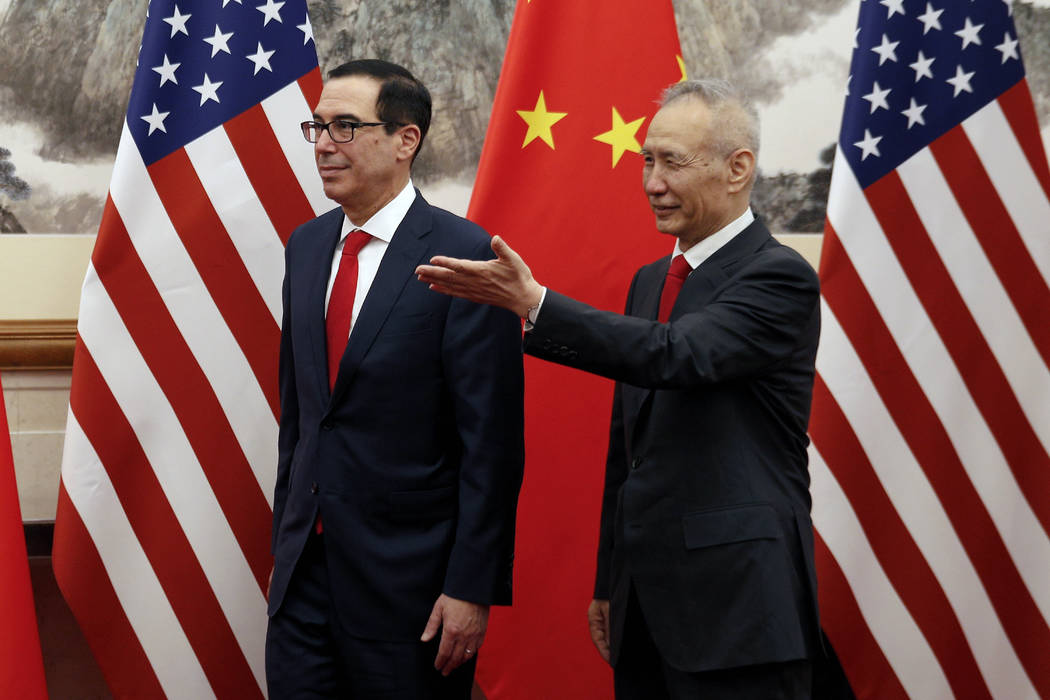 Chinese Vice Premier Liu He, right, shows the way to U.S. Treasury Secretary Steven Mnuchin as ...