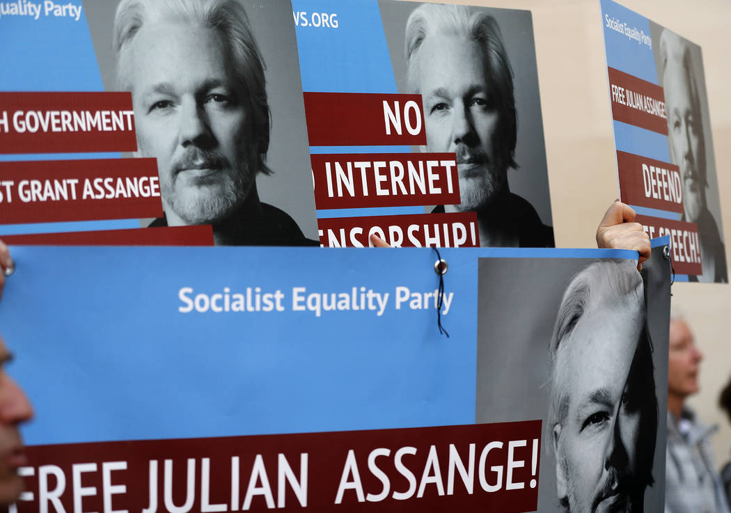 Protestors brandish posters depicting Julian Assange as they demonstrate at the entrance of Wes ...