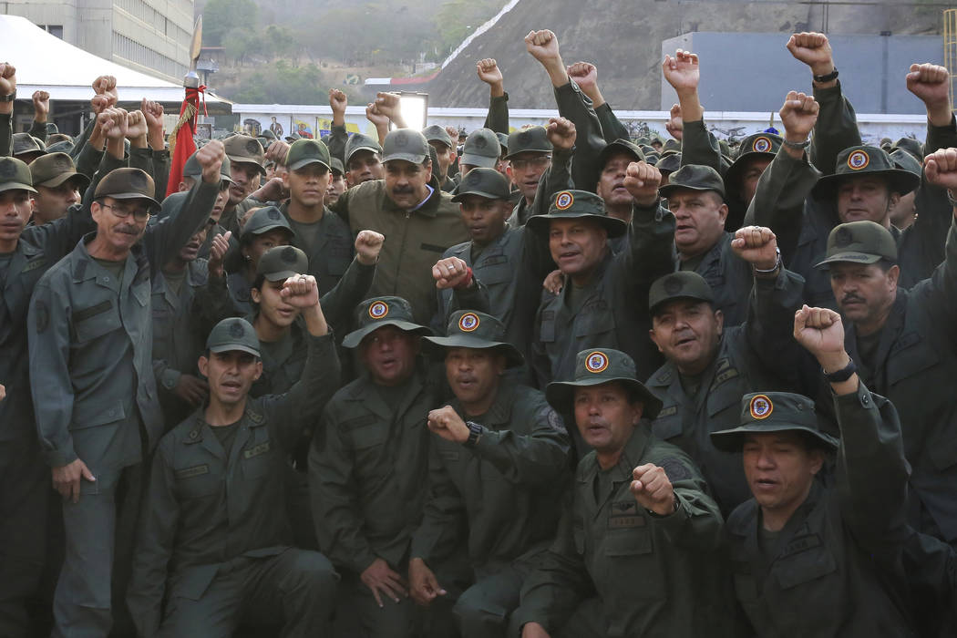 In this photo released by Miraflores Press Office, Venezuela's President Nicolas Maduro, center ...