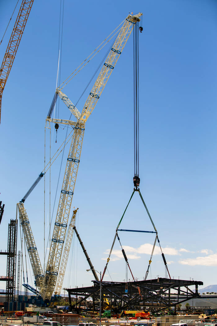 The newest truss is secured to a crane soon to be lifted and attached to top of Raiders Stadium ...