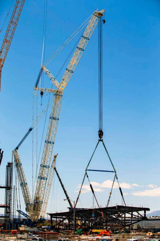 The newest truss is secured to a crane soon to be lifted and attached to top of Raiders Stadium ...