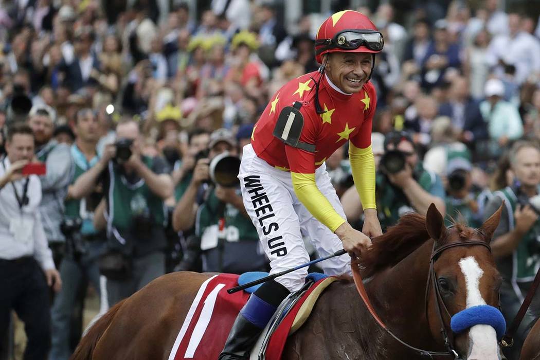 Jockey Mike Smith celebrates riding Justify to win the 150th running of the Belmont Stakes and ...