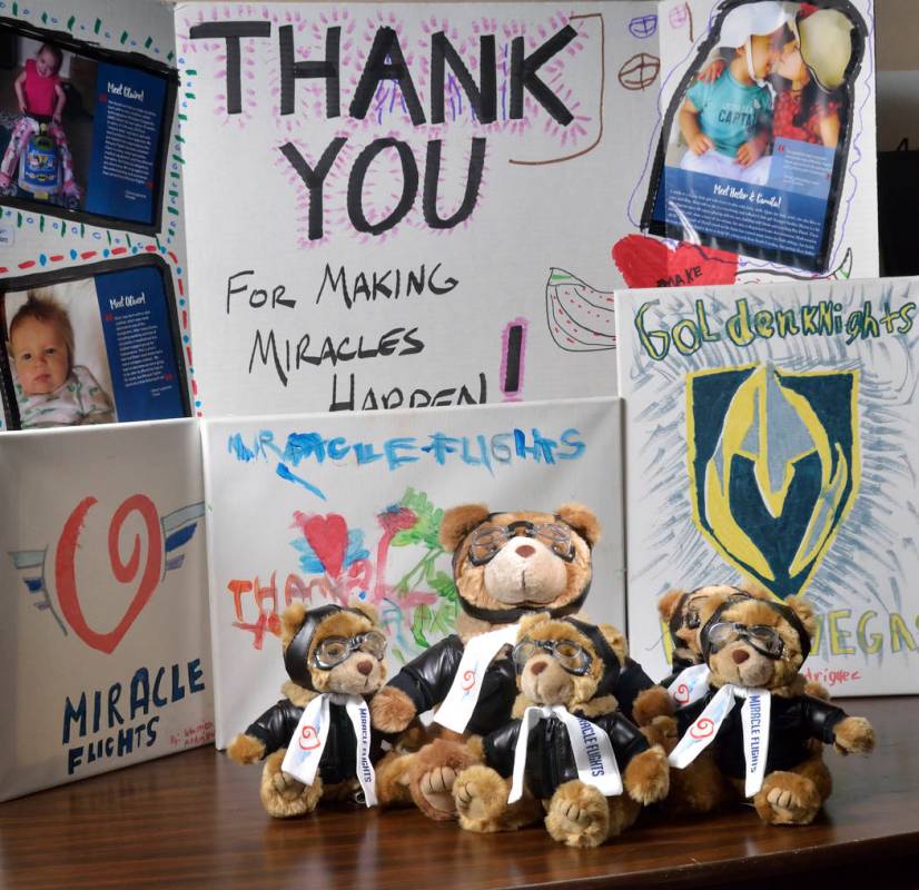 Miles the Bear mascots and a thank you poster and paintings are shown at the Miracle Flights of ...