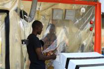 Kasereka Mulanda, 24, talks with his wife who is suffering from the Ebola virus in an isolation ...