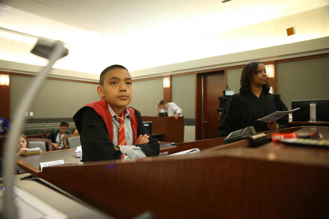 Playing as an attorney Jaivian Gonzalez, 10, with Judge Tierra Jones, participate during a mock ...