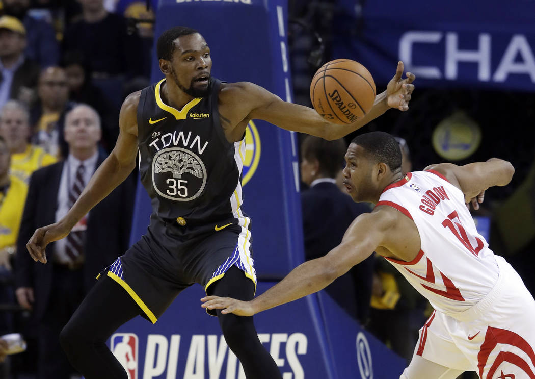 Golden State Warriors' Kevin Durant (35) is defended by Houston Rockets' Eric Gordon during the ...