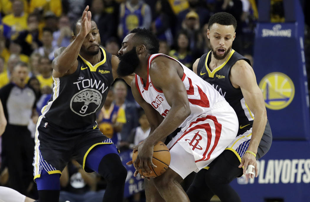 Houston Rockets' James Harden, center, is defended by Golden State Warriors' Andre Iguodala, le ...