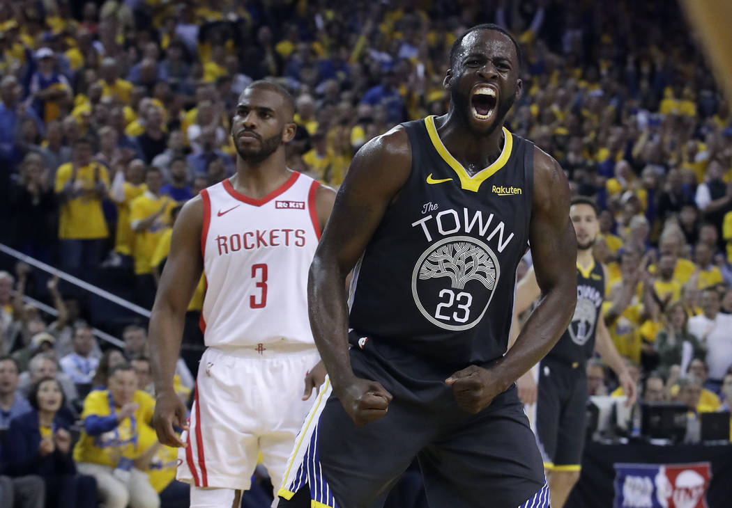 Golden State Warriors' Draymond Green (23) reacts after scoring, in front of Houston Rockets' C ...