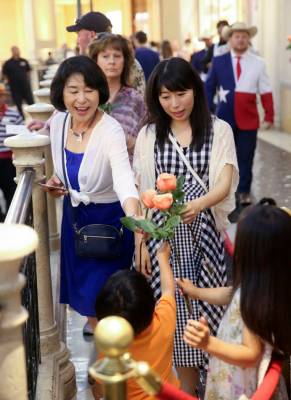 Reiko Yuasa, left, and Kanako Arai of Japan share their free roses with Arai's children Shotaro ...