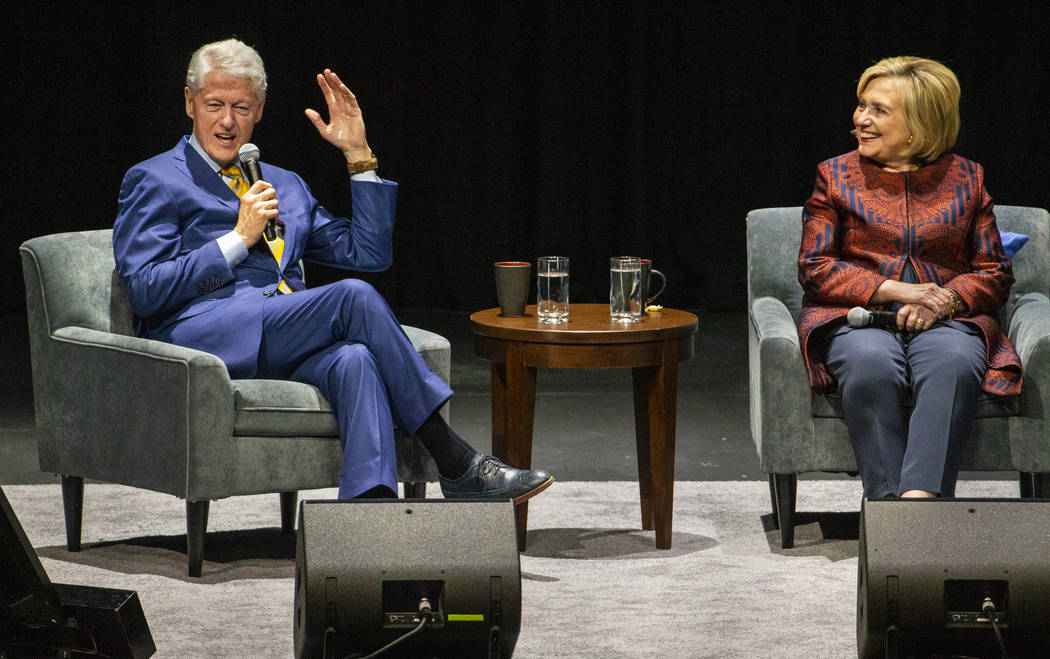 Former U.S. President Bill Clinton tells a story seated beside former U.S. Secretary of State H ...