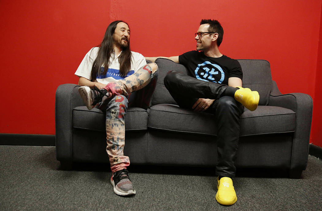 Steve Aoki, left, and Tom Bilyeu, right, sit for a portrait during a comic book signing of his ...