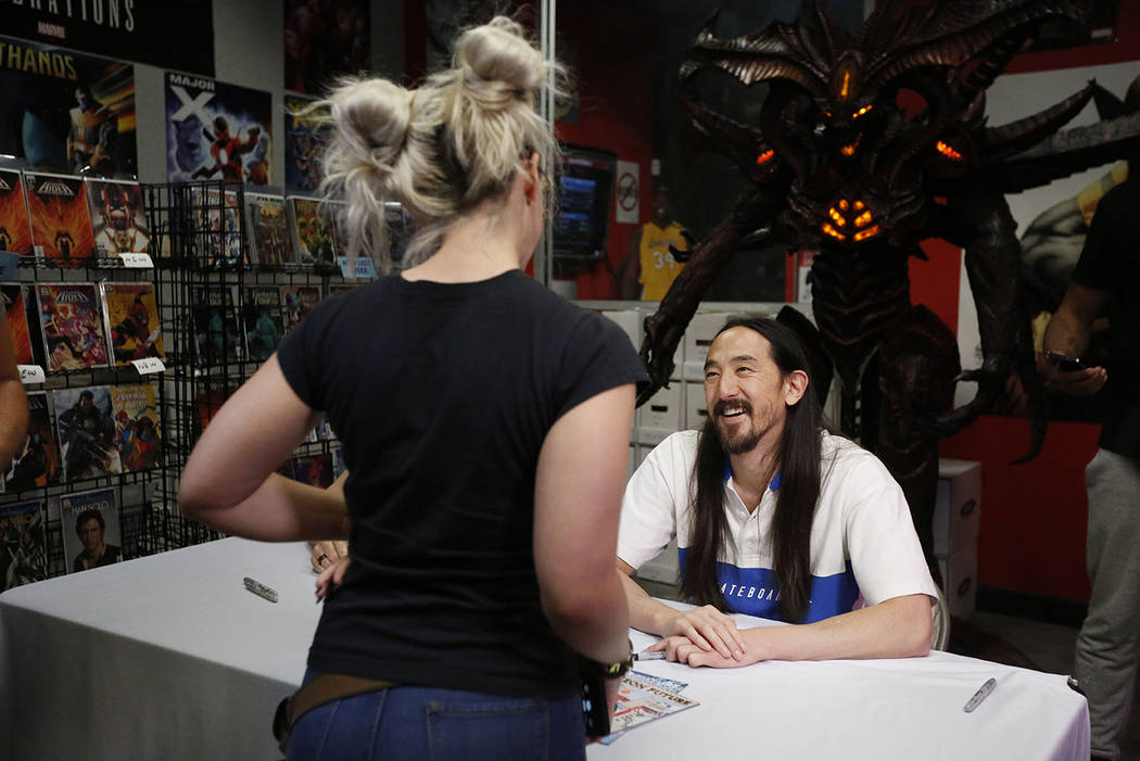 Steve Aoki talks to a fan during a comic book signing of his new "Neon Future" comic ...