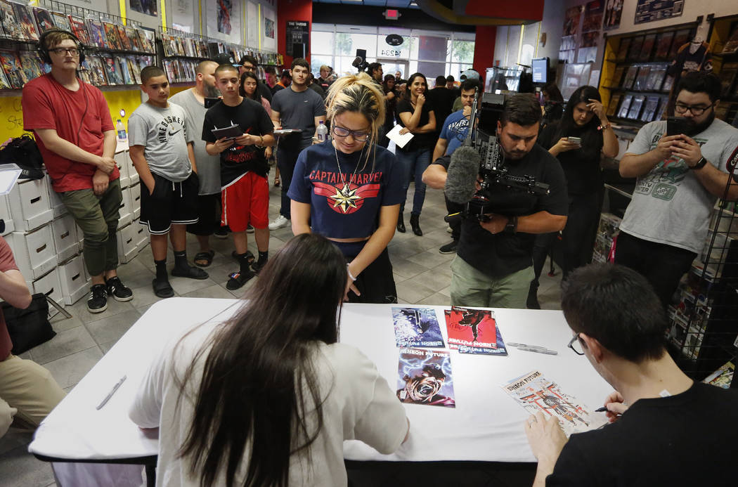 A large group of fans gather to get autographs from Steve Aoki during a comic book signing of h ...