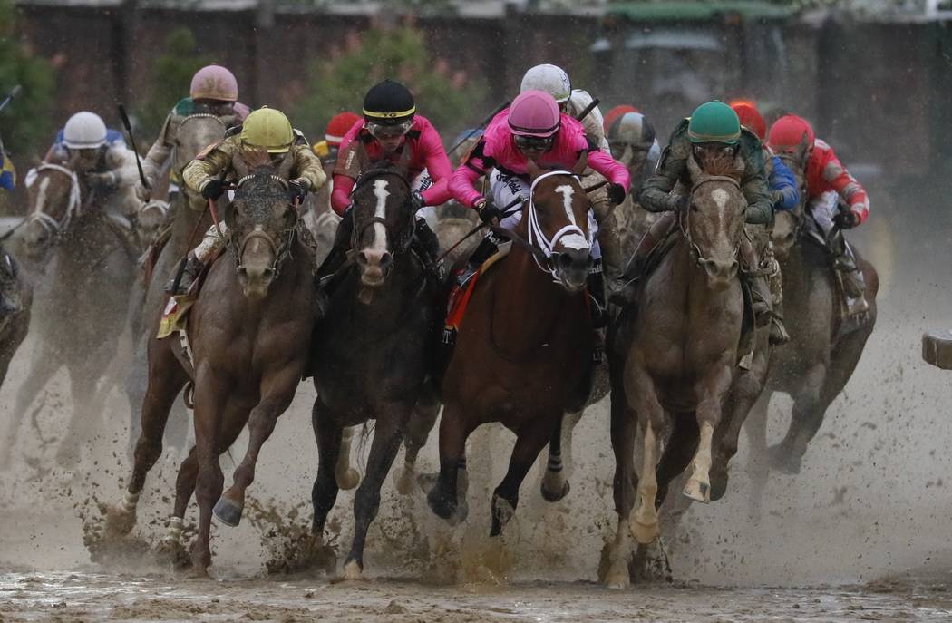 Luis Saez riding Maximum Security, second from right, goes around turn four with Flavien Prat r ...