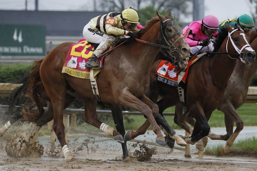 Luis Saez rides Maximum Security, center, crosses the finish line first ahead of Country House, ...